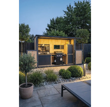 Moderne Außenküche im Garten mit Gasgrill, Holzverkleidung und Beleuchtung. Gut organisierter Grillplatz auf einer gepflasterten Steinterrasse.