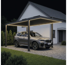 Moderner Carport mit LED-Beleuchtung und Lamellendach, Auto auf gepflasterter Einfahrt vor einem Haus bei Nacht.