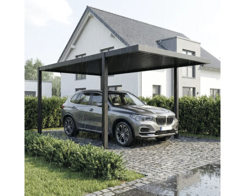 Freistehender Aluminium-Carport mit Lamellendach, unter dem ein SUV bei Regen auf einer gepflasterten Einfahrt vor einem Haus parkt.