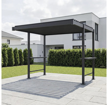 Moderne dunkle Pergola aus Metall mit Lamellendach auf einer gepflasterten Terrasse im Garten vor einer Hecke und einem Wohnhaus.