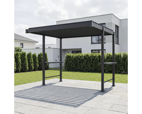 Moderne dunkle Pergola aus Metall mit Lamellendach auf einer gepflasterten Terrasse im Garten vor einer Hecke und einem Wohnhaus.