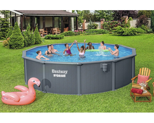 Bestway Hydrium Stahlwandpool im Garten mit badenden Personen und aufblasbarem Flamingo auf der Rasenfläche.