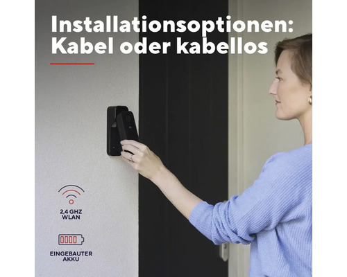 Frau montiert eine schwarze Videotürklingel an einer Wand. Text beschreibt Installationsoptionen mit Kabel oder kabellos mit eingebautem Akkumulator.