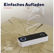 Smarte Türklingel wird über ein USB-C-Kabel an einer Steckdose aufgeladen. Das Gerät liegt auf einer Holzoberfläche.