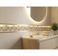 Helles Badezimmer mit großformatigen Wandfliesen, einem Mosaikstreifen aus Glas und Gold mit LED Beleuchtung, einem runden Leuchtspiegel und einem Waschtisch aus Holz.