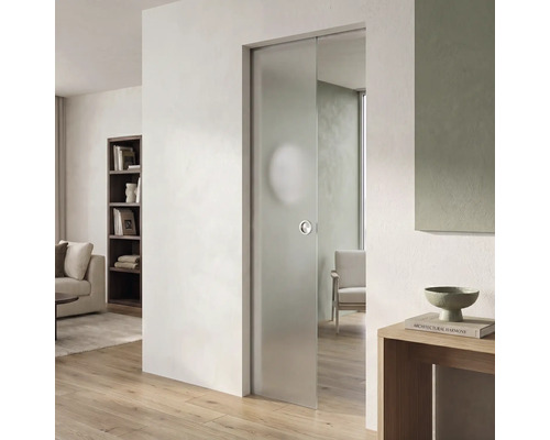Moderne Glasschiebetür aus Milchglas in einem hellen Wohnzimmer mit hellem Parkettboden und weißer Wand.