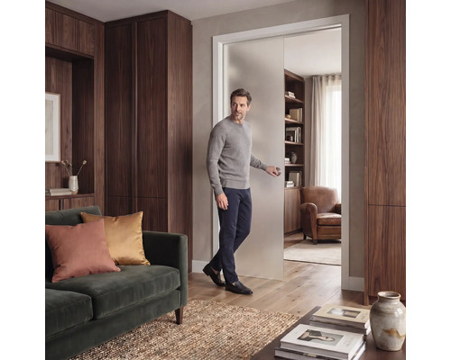 Modernes Wohnzimmer mit einer Schiebetür aus Mattglas, Schränken aus dunklem Holz und einem grünen Samtsofa.