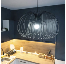 Moderne Pendelleuchte aus Metalldraht in einer Küche mit dunklen Schränken und Holzarbeitsplatte.