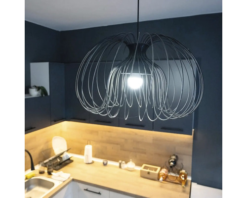 Moderne Pendelleuchte aus Metalldraht in einer Küche mit dunklen Schränken und Holzarbeitsplatte.
