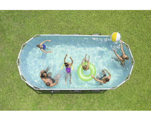 Ovaler Aufstellpool mit Metallrahmen im Garten, mehrere Personen schwimmen und spielen mit Wasserball und Schwimmring im Wasser.