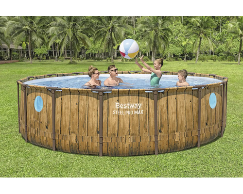 Bestway Steel Pro MAX runder Rahmenpool in Holzoptik mit Sichtfenstern. Familie spielt mit Wasserball im Pool in einem Garten mit Palmen.
