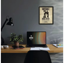Gerahmtes Harry Potter Poster Undesirable Nummer 1 an einer grauen Wand über einem organisierten Holzschreibtisch mit Laptop und Lampe.