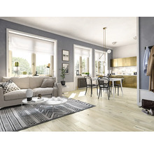 Heller Wohnbereich mit Laminatboden, beigem Sofa, gemustertem Teppich und angrenzendem Essbereich mit weißem Tisch und schwarzen Stühlen.