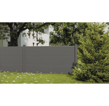 Moderner grauer Sichtschutzzaun mit horizontalen Paneelen und Pfosten in einem hellen Garten mit Rasen und Bäumen.