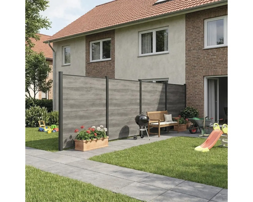 Moderner Sichtschutzzaun in Holzoptik mit horizontalen Lamellen in einem hellen, ordentlichen Garten mit Terrasse, Gartenbank und Grill.