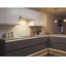 Moderne Einbauküche mit weißen Oberschränken, grauen Unterschränken und integrierter LED-Beleuchtung unter der Arbeitsplatte und am Sockel.