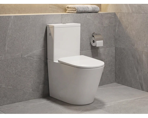 Modernes Stand-WC aus Keramik mit Spülkasten in einem Badezimmer mit grauen Fliesen in Natursteinoptik.