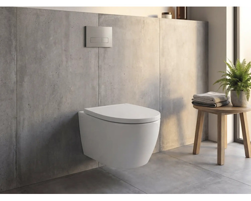 Wand-WC in einem modernen Badezimmer mit Betonoptik, Drückerplatte an der Wand und einem Holzhocker mit Handtüchern und Pflanze.