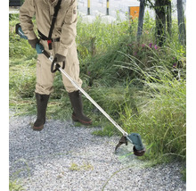 Person bei Gartenarbeiten mit einer Makita Akku-Motorsense an einem Wegrand mit hohem Gras.