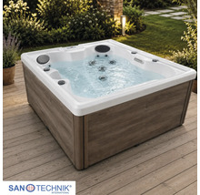 Sanotechnik Außenwhirlpool mit Verkleidung in Holzoptik auf einer Holzterrasse im Garten mit Massagedüsen und Kopfstützen.