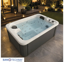 Rechteckiger Außen-Whirlpool mit grauer Verkleidung, weißem Innenbecken, Massagedüsen und Kopfstützen auf einer Terrasse. Sanotechnik Logo.