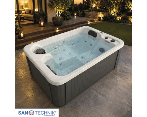 Rechteckiger Außen-Whirlpool mit grauer Verkleidung, weißem Innenbecken, Massagedüsen und Kopfstützen auf einer Terrasse. Sanotechnik Logo.