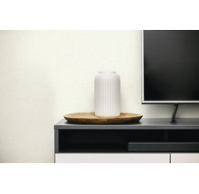 Strukturierte Tapete in modernem Wohnzimmer mit weißer Vase auf Holztablett und dunklem Sideboard.