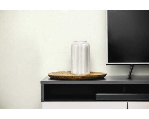 Strukturierte Tapete in modernem Wohnzimmer mit weißer Vase auf Holztablett und dunklem Sideboard.