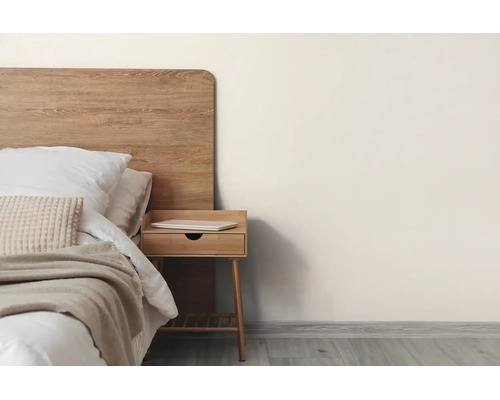 Helles Schlafzimmer mit Holzkopfteil, Nachttisch, weißem Bettzeug und hellbeiger Wandfarbe.