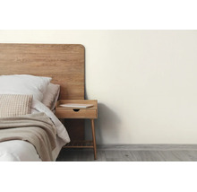Modernes Schlafzimmer mit cremefarbener Wand, Holzbett, passendem Nachttisch und hellem Bodenbelag in Holzoptik.