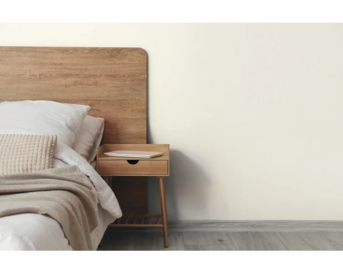 Modernes Schlafzimmer mit cremefarbener Wand, Holzbett, passendem Nachttisch und hellem Bodenbelag in Holzoptik.