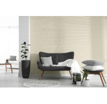 Tapete mit Kreismuster in einem hellen, modern eingerichteten Wohnzimmer mit dunklem Sofa und Zimmerpflanzen.