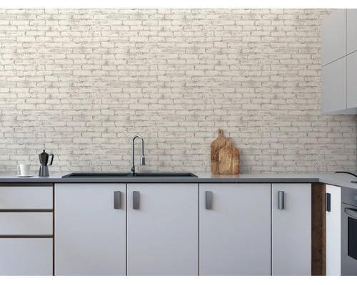 Moderne Küche mit weißen Schränken und Vliestapete in Ziegelsteinoptik an der Wand. Inklusive Spüle, Wasserhahn und Küchenzubehör.
