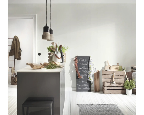 Helle, moderne Küche mit grauer Kücheninsel, zwei Beton-Pendelleuchten, Holzkisten zur Aufbewahrung und einer beschrifteten Kreidetafel.