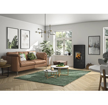 Modernes, helles Wohnzimmer mit schwarzem Kaminofen, braunem Ledersofa, Couchtischen auf grünem Teppich und Holzfußboden.
