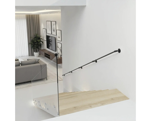 Schwarzer Handlauf aus Metall im Industrial-Stil an einer weißen Wand über einer Holztreppe mit Glasgeländer in einem modernen Wohnzimmer.