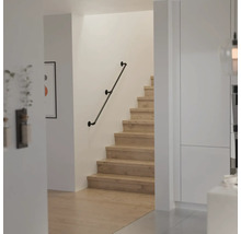 Moderner Treppenaufgang mit Holzstufen und einem Wandhandlauf im Industriedesign aus Metallrohren.
