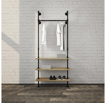 Offene Garderobe im Industrial-Stil aus schwarzen Metallrohren mit Kleiderstange und drei Holzregalen vor einer Ziegelwand.