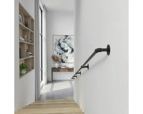 Schwarzer Handlauf aus Metall im Industrie-Design an einer weißen Wand in einem hellen, modernen Flur mit Holztreppe.