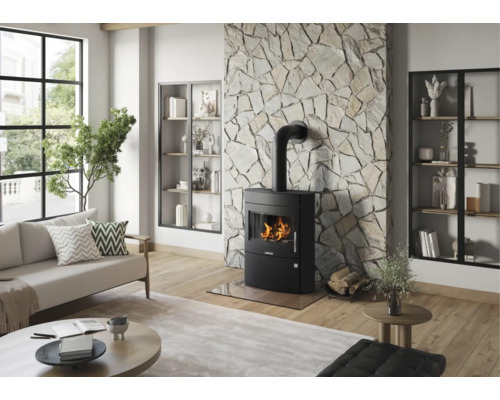 Modernes, helles Wohnzimmer mit schwarzem Kaminofen vor einer Natursteinwand, Holzboden und großem Fenster.