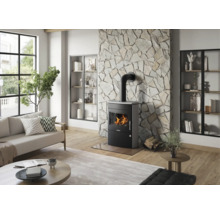 Moderner Kaminofen in einem hellen Wohnzimmer vor einer Wand mit Natursteinverkleidung, Parkettboden und Sofa.