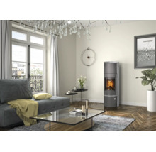 Moderner Kaminofen in einem hellen Wohnzimmer mit Parkettboden, Sofa und großem Kronleuchter.