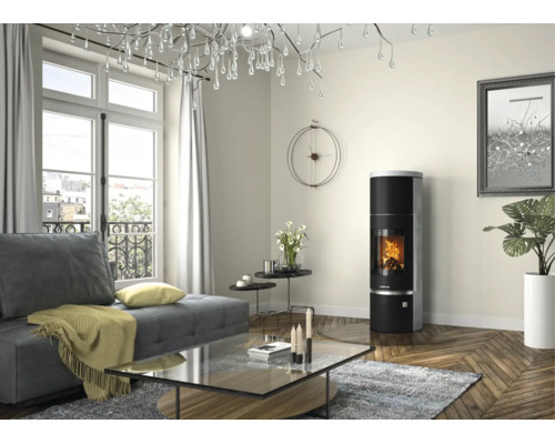 Modernes helles Wohnzimmer mit rundem schwarzem Kaminofen mit brennendem Feuer, grauem Sofa und gläsernem Couchtisch auf Holzparkett.