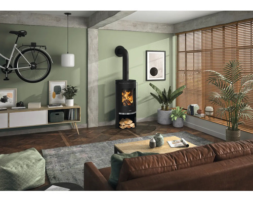 Moderner Kaminofen in einem hellen Wohnzimmer mit Parkettboden, Ledersofa und großen Fenstern mit Holzjalousien.