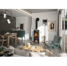 Moderner schwarzer Kaminofen mit brennendem Feuer im stilvoll eingerichteten Wohnzimmer mit Sessel, Couchtisch und Essbereich.