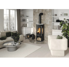 Modernes, helles Wohnzimmer mit einem schwarzen Kaminofen vor einer Steinwand, Sofa, Sessel und Couchtisch.