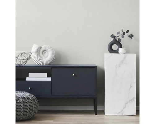 Modernes Wohnzimmer mit dunklem Sideboard, Marmor-Podest, dekorativer Muschel, Vase und grauem Strick-Pouf.