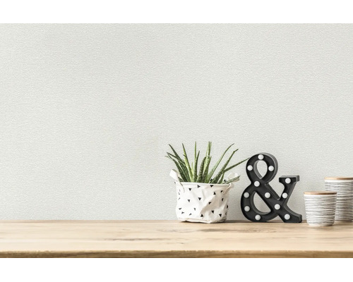 Strukturierte Tapete in hellem Raum mit Aloe Vera, leuchtendem Et-Zeichen und Keramikdosen auf Holzoberfläche.