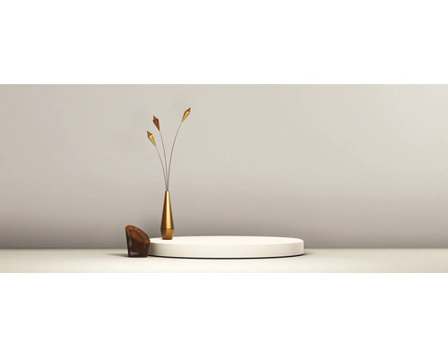 Minimalistische Einrichtung mit einem runden weißen Podest, einer schlanken goldenen Vase mit Dekostielen und einem kleinen geflochtenen Element.