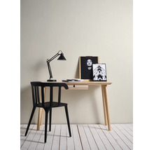 Minimalistischer Arbeitsplatz mit hellem Holzschreibtisch mit Schublade, modernem schwarzem Stuhl und schwarzer Schreibtischlampe.